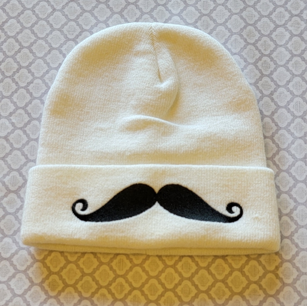 white beanie w/ black mustache on brim
